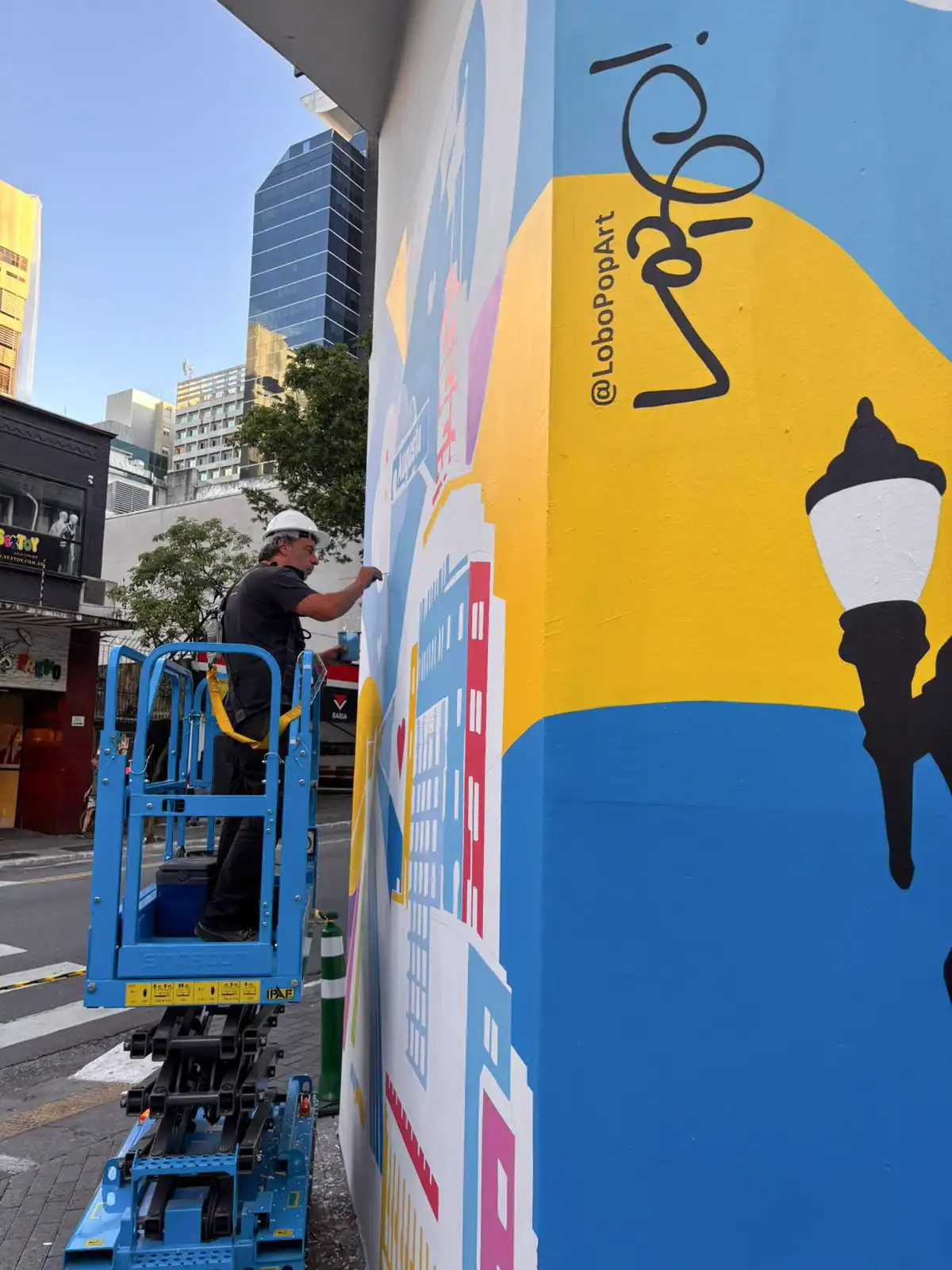 Lobo Pop Art pinta em plataforma elevatória ao lado de sua assinatura na Rua Augusta