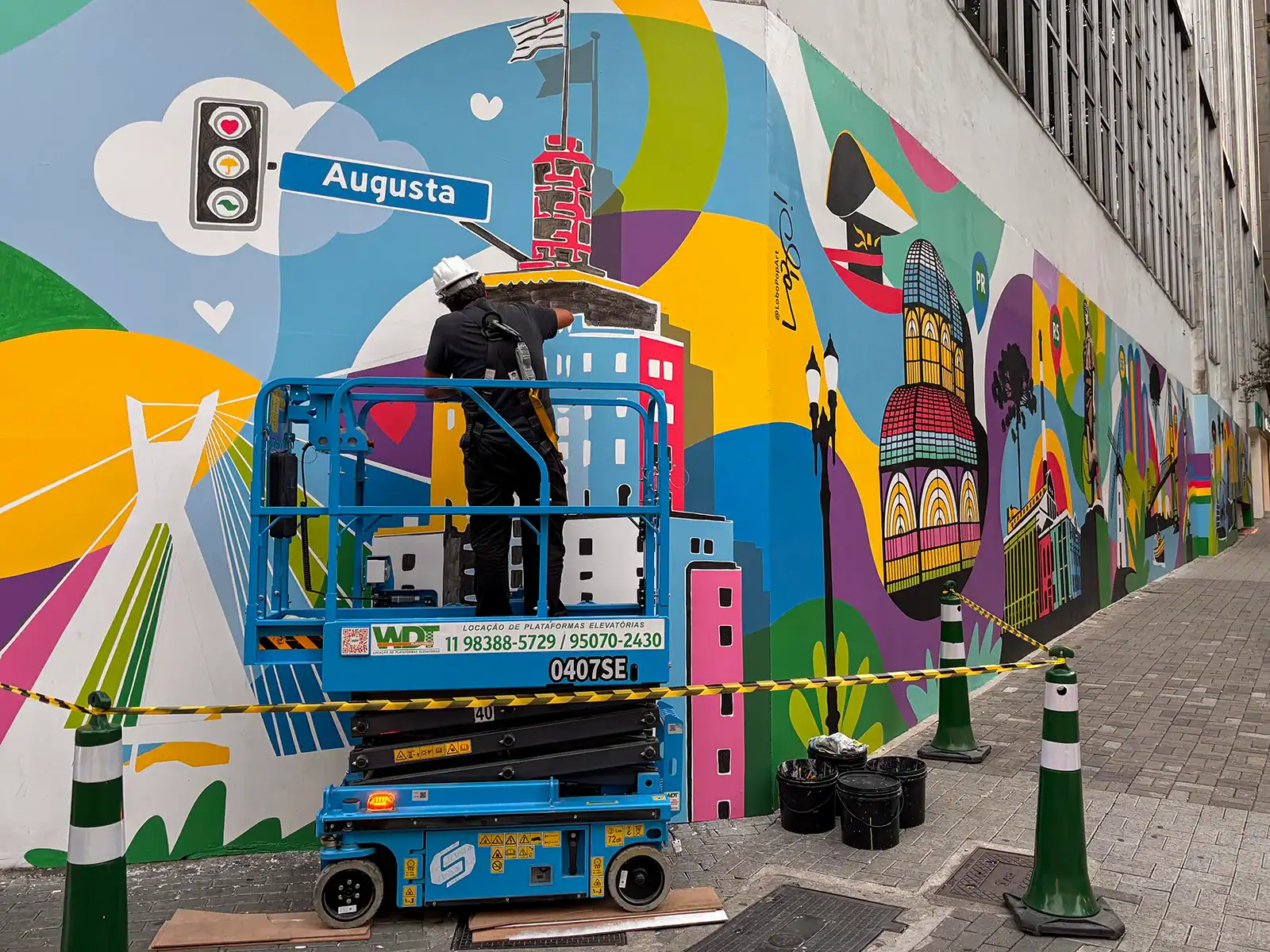 Lobo Pop Art trabalha em plataforma elevatória durante a pintura na Rua Augusta